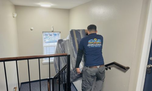 “Movers carrying a sofa down the stairs during an apartment move in Alexandria VA – Noah’s Relocation Services”